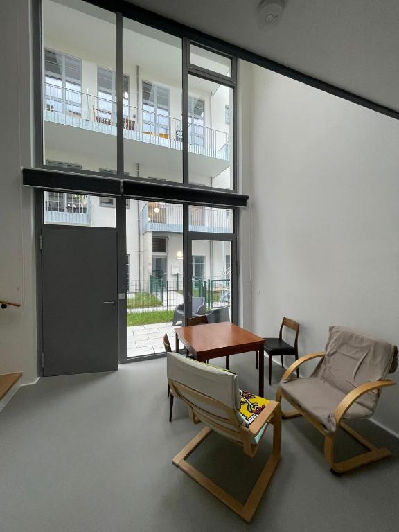 a living room with chairs and a table and a window at Modern Loft mit Terrasse in Vienna