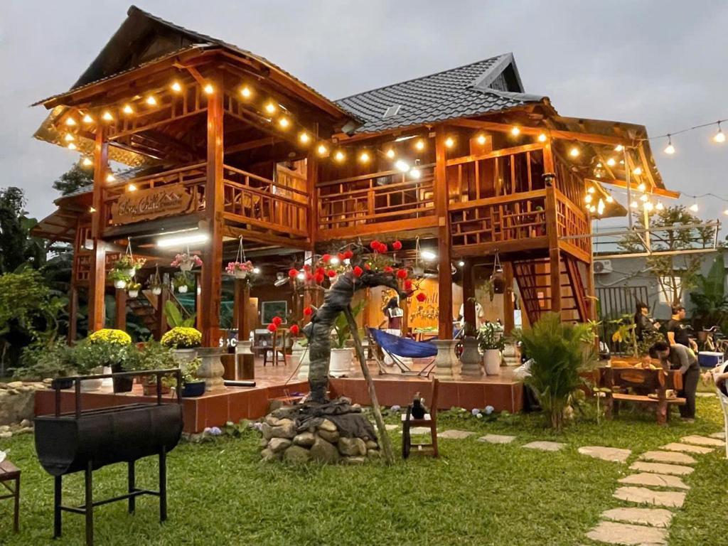 a large wooden building with a statue in the yard at Sống Chill Homestay in Nam Yên