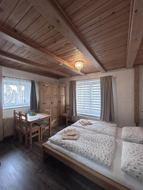 a bedroom with two beds and a table in it at Párty penzion Dolany in Čkyně