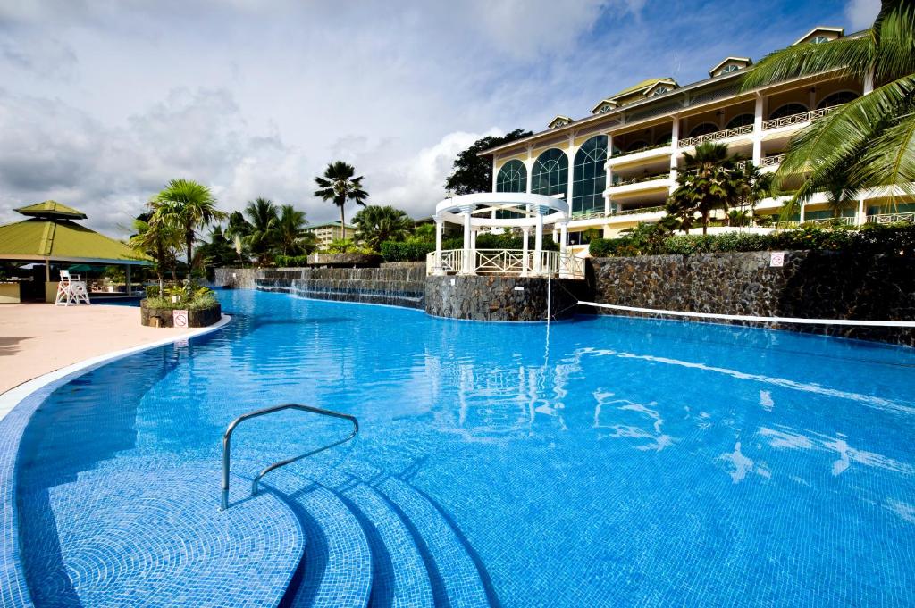 a large blue swimming pool next to a building at Gamboa Rainforest Reserve in Gamboa