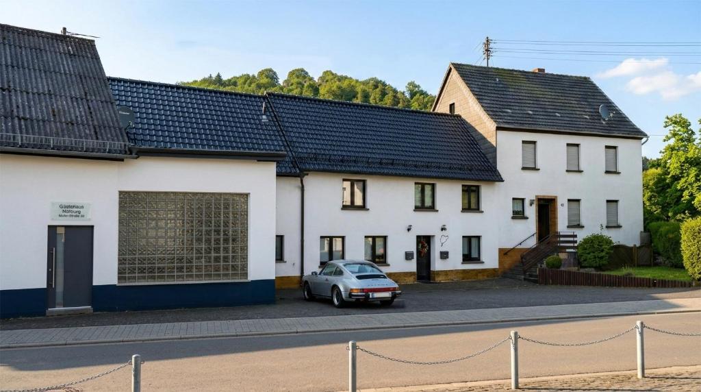 a car parked in front of two white houses at GT Nord Hof in Müllenbach