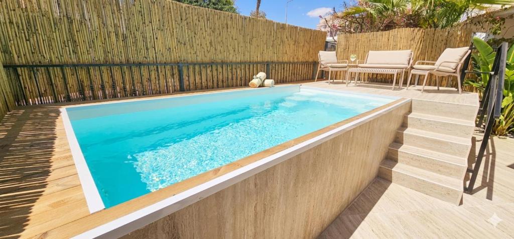 a swimming pool in a backyard with a wooden fence at Amdar Holiday Apartments in Eilat