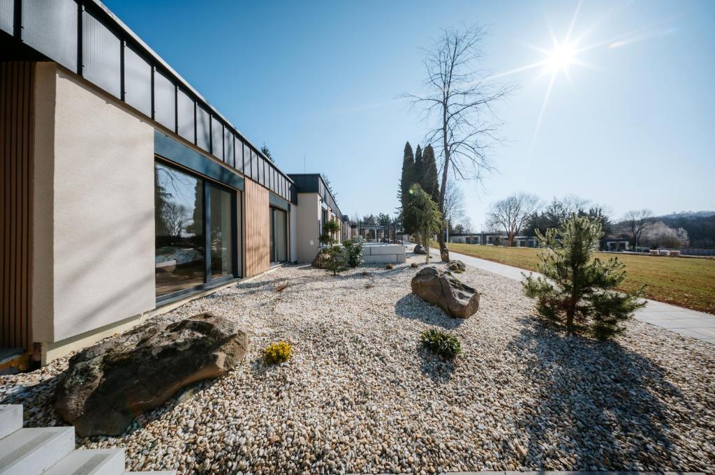 a house with a gravel yard next to a building at Kotva By Momoland - Apartmán in Ružiná