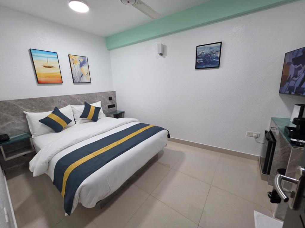 a bedroom with a large bed with yellow and blue pillows at Tour Inn in Male City