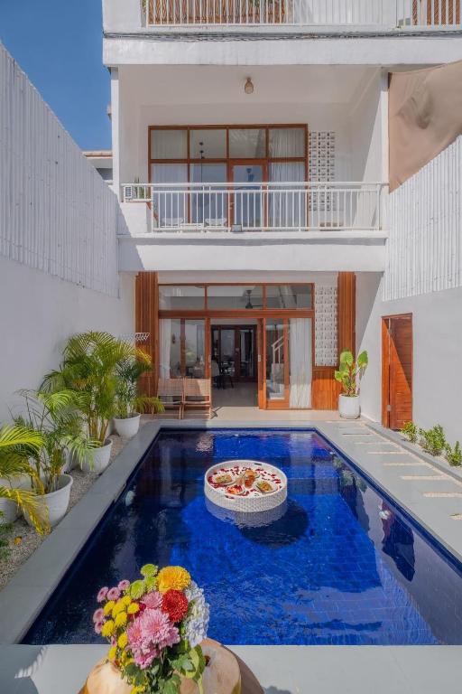 a villa with a swimming pool in front of a house at Villa OG Cruz in Canggu