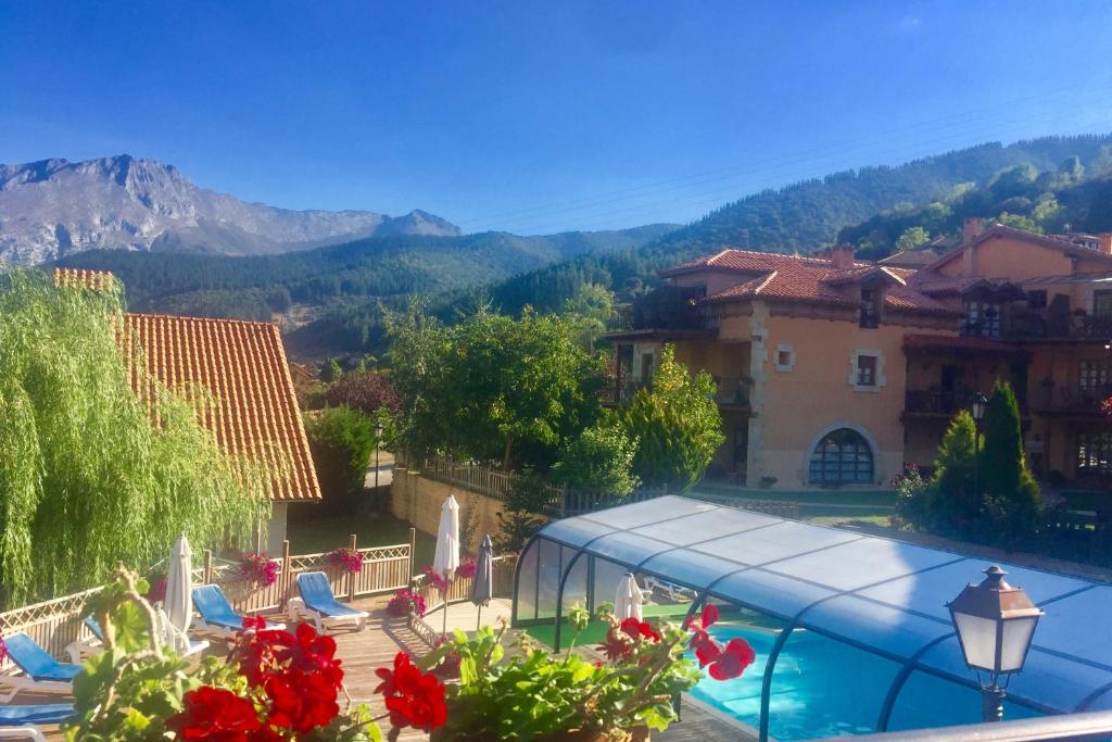 - Vistas a un complejo con piscina y montañas en Apartamentos Alquitara en Ojedo