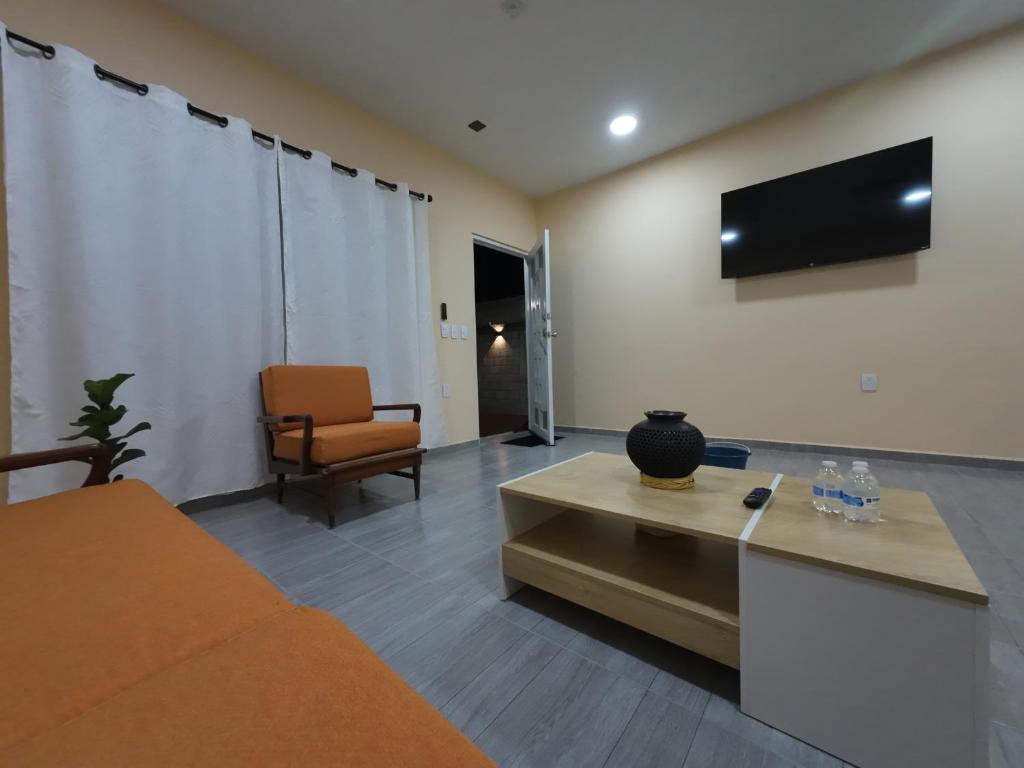 a living room with a couch and a tv on the wall at Casa ilusion Tuxpan Veracruz in Tampamachoco