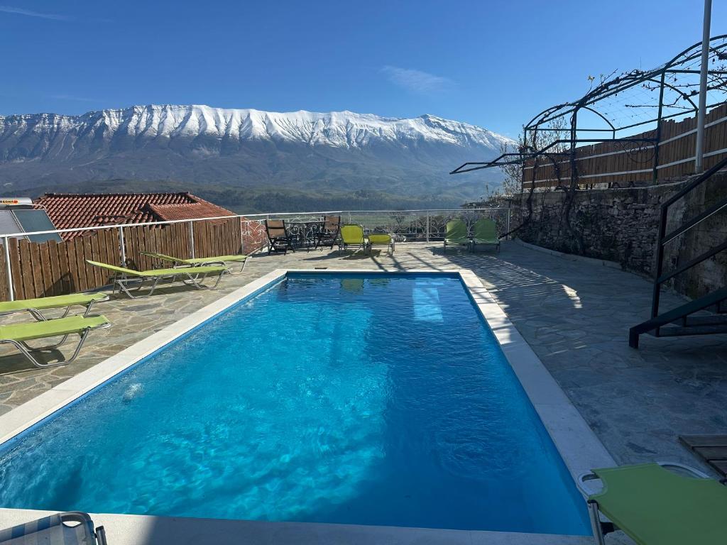 a swimming pool with a mountain in the background at Guesthouse Mele in Gjirokastër