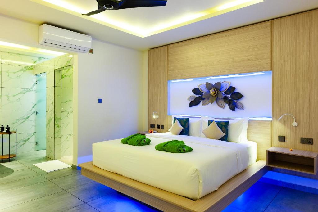 a bedroom with a large white bed with a flower on the wall at Cote d'Or Retreat in Anse Volbert Village