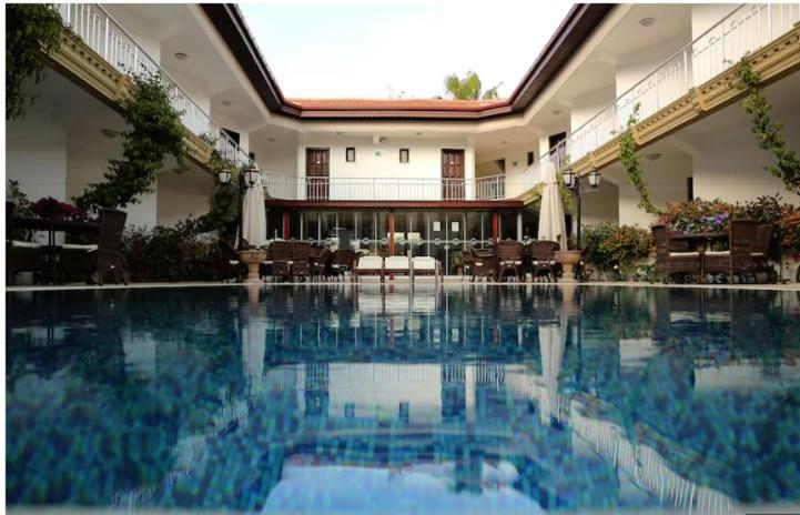 a large swimming pool in a building with tables and chairs at So Dalyan in Ortaca