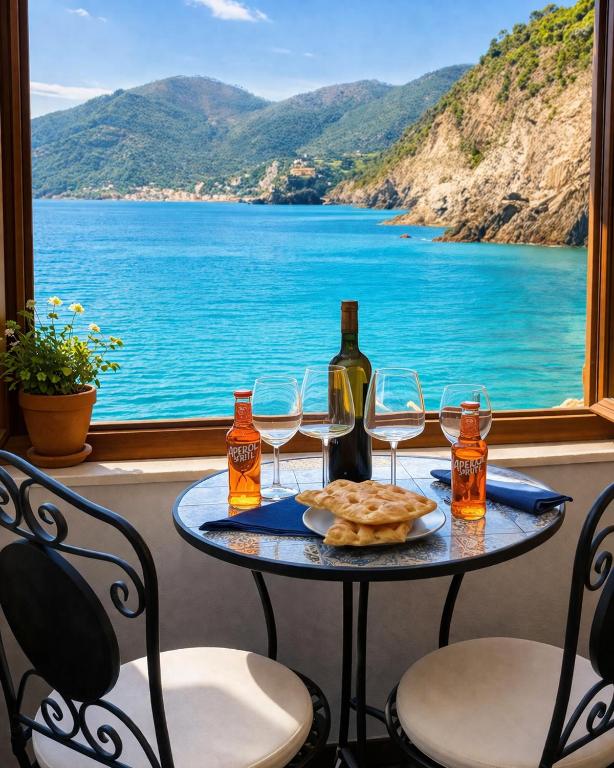 a table with a bottle of wine and wine glasses at La Randa apartment in Vernazza