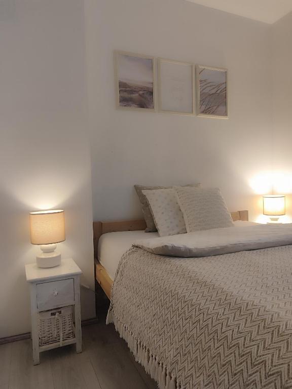 a bedroom with a bed with two lamps on it at PortStreet apartamenti in Liepāja