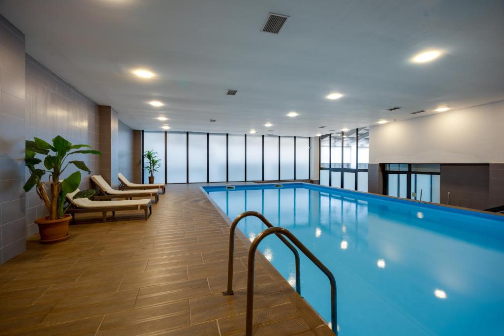 a large swimming pool with chairs at Pine Astoria Hotel in Tbilisi City
