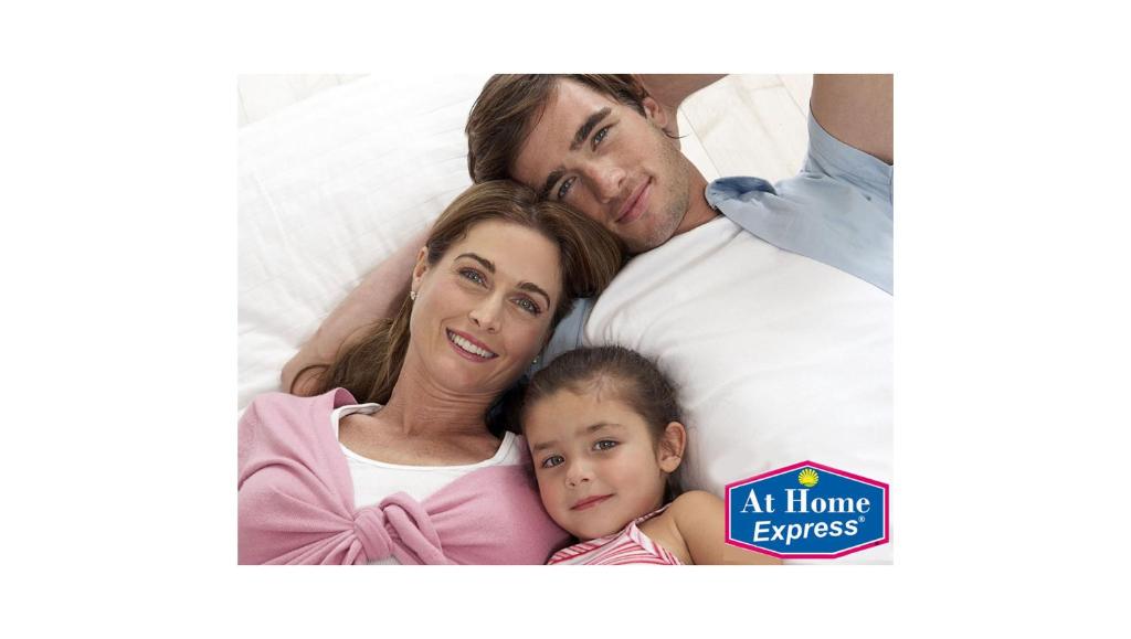 a family laying in bed with their daughter at At Home Express Tangerine Inn in DeLand
