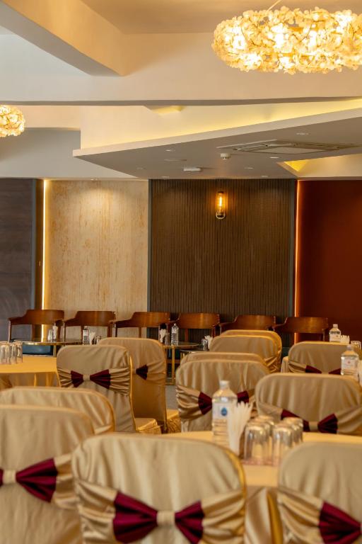a restaurant with white chairs and tables and a chandelier at Mandala Norling Lords Prime Kathmandu in Kathmandu