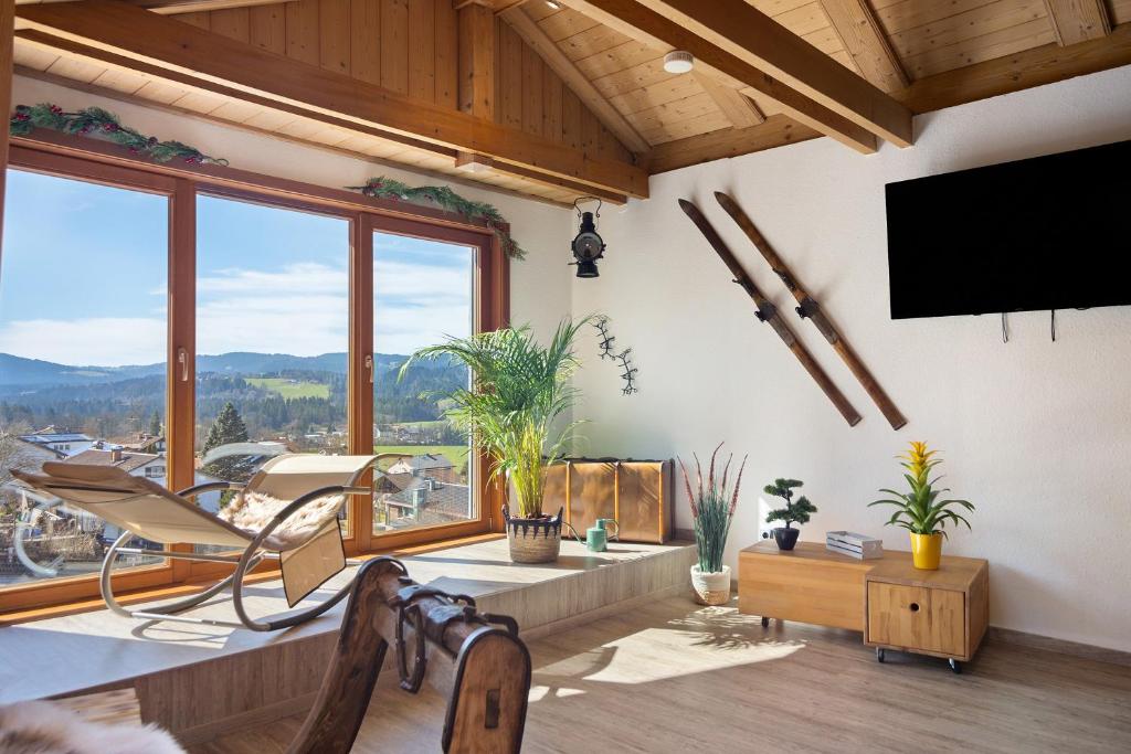 a living room with a large window and a flat screen tv at Weitsicht in Weiler-Simmerberg