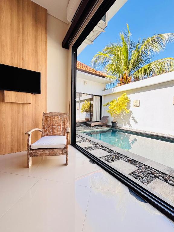 a living room with a view of a swimming pool at Villa Reisya in Nusa Dua