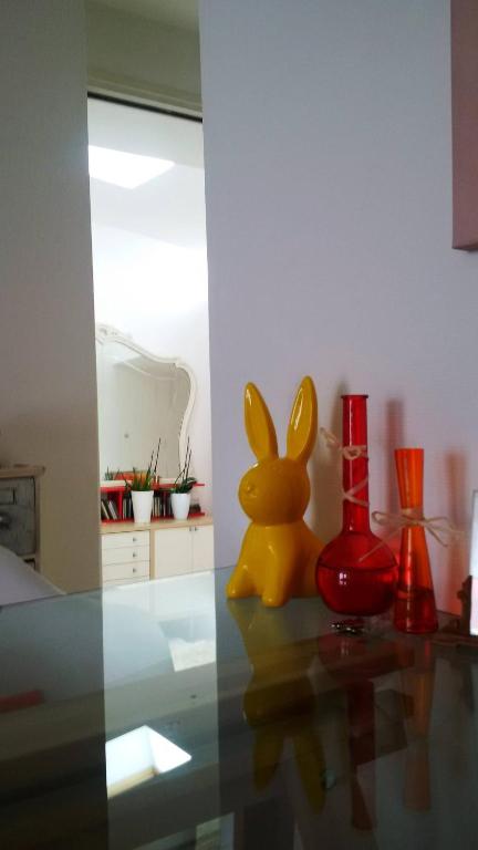 a yellow bunny sitting on a glass table with vases at Chambre double 30km de la Tour Eiffel in Saint-Michel-sur-Orge