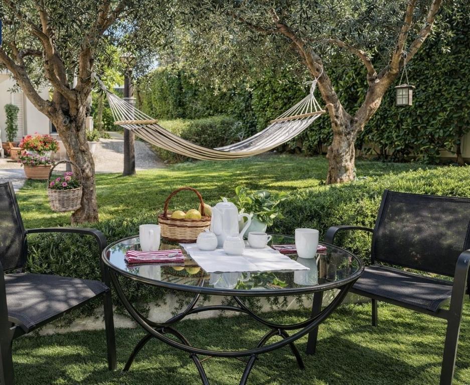 a hammock in a garden with a table and chairs at Villa Volli Three Rooms in Agrigento