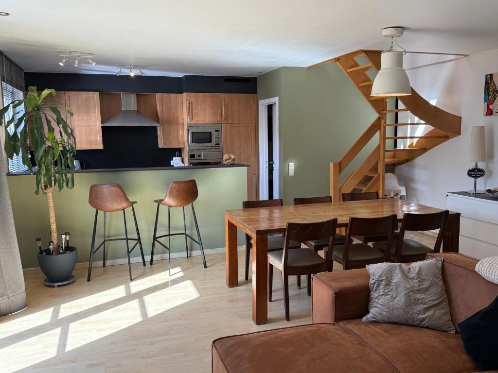 a kitchen and living room with a table and chairs at Duplex vernieuwd appartement Dujardin bubbelbad in Blankenberge