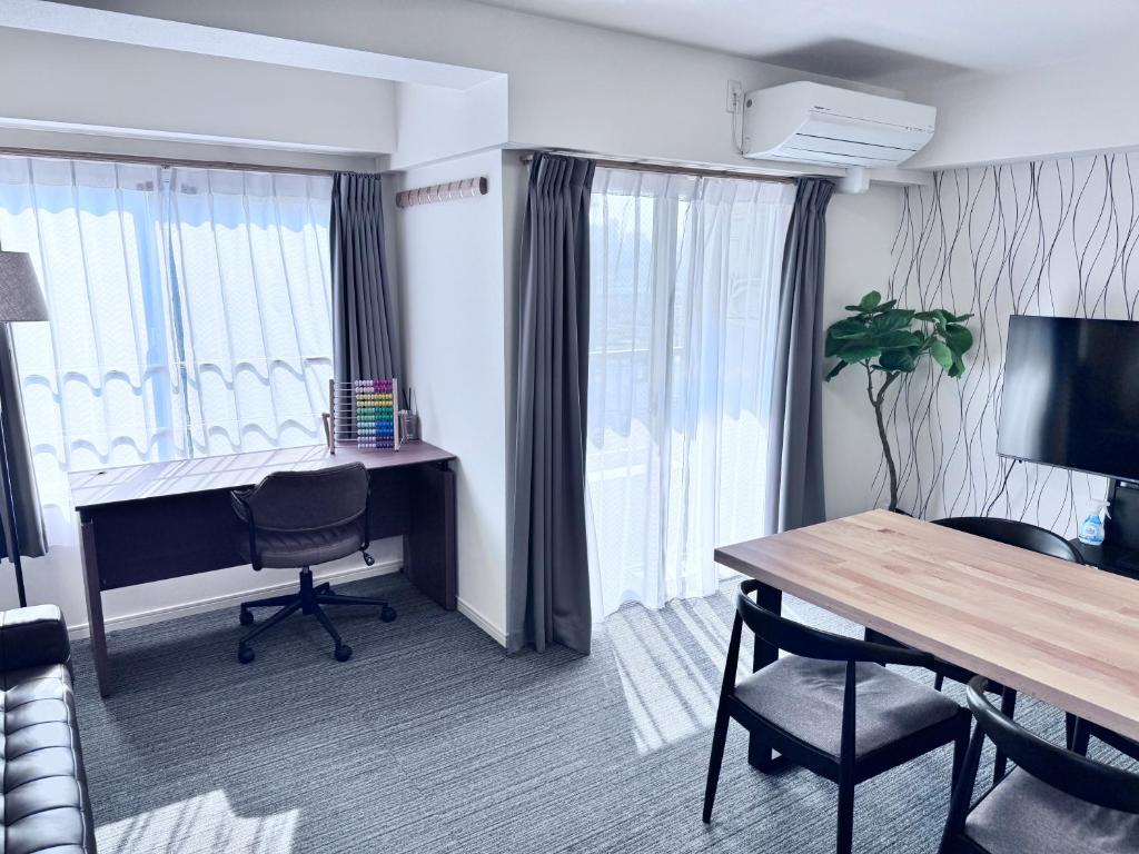 a hotel room with a desk and a table and chairs at Ito House in Tokyo