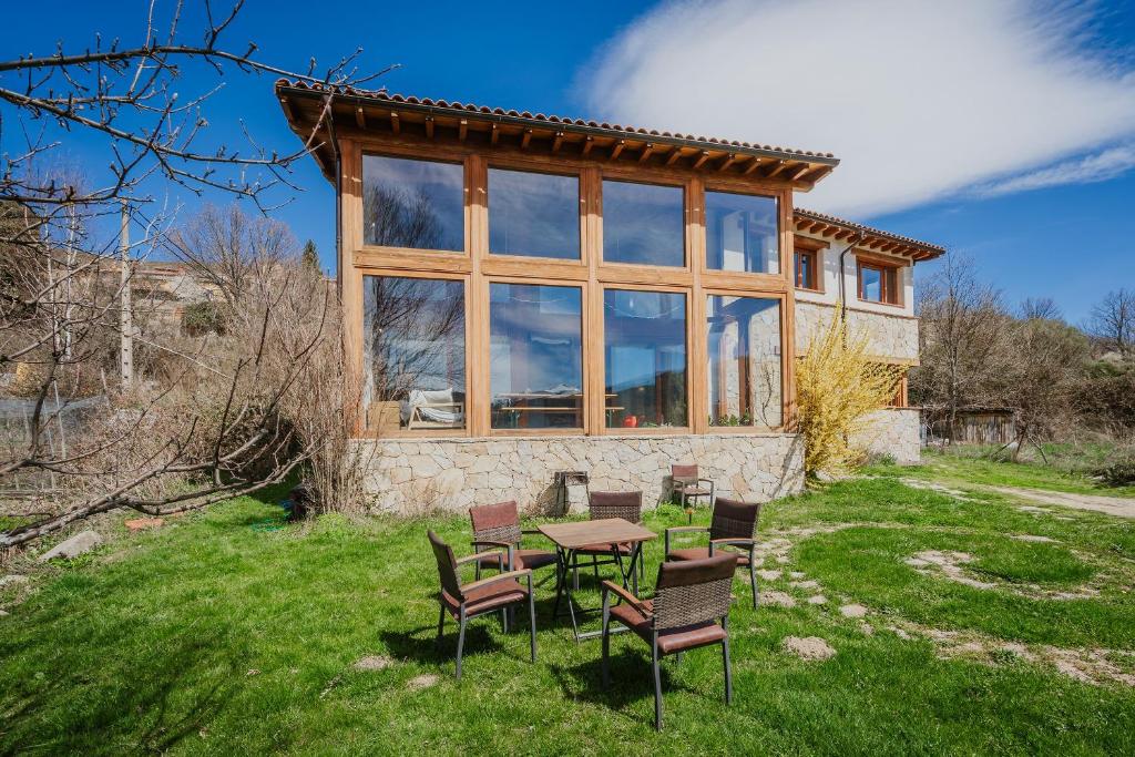 a house with a table and chairs in the grass at Ecolgica Casa Del Sol 1 in Navacepeda de Tormes