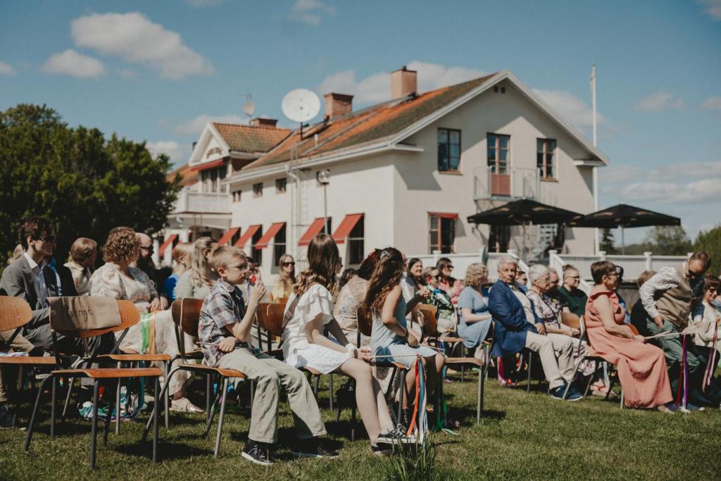 a crowd of people sitting in chairs in front of a building at Bångbro Herrgård in Kopparberg