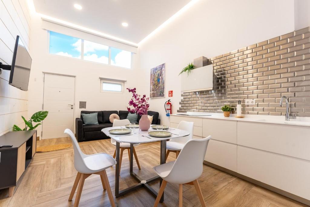 a kitchen and living room with a table and chairs at El loft del sardi in Santander