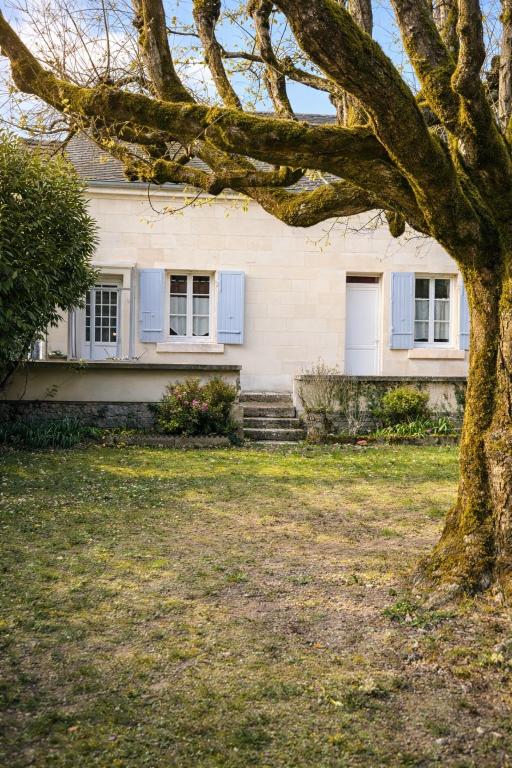 a white house with blue windows and a tree at Maison de la Vallée - proche Zoo Beauval in Angé