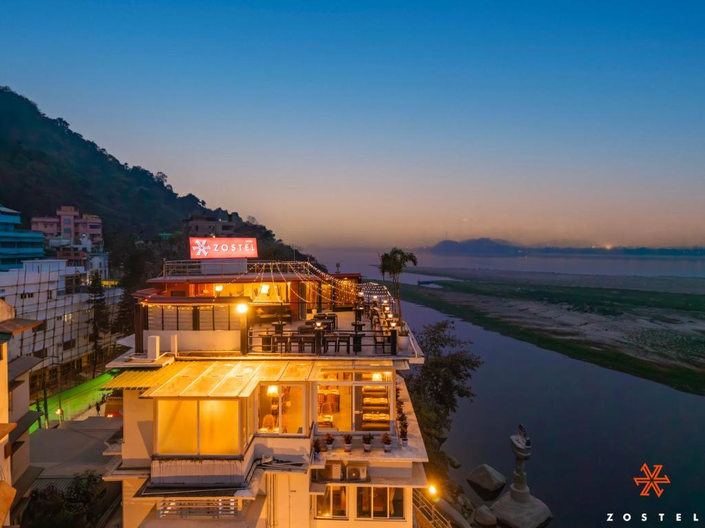 a view of a building on the water at night at Zostel Guwahati in Guwahati