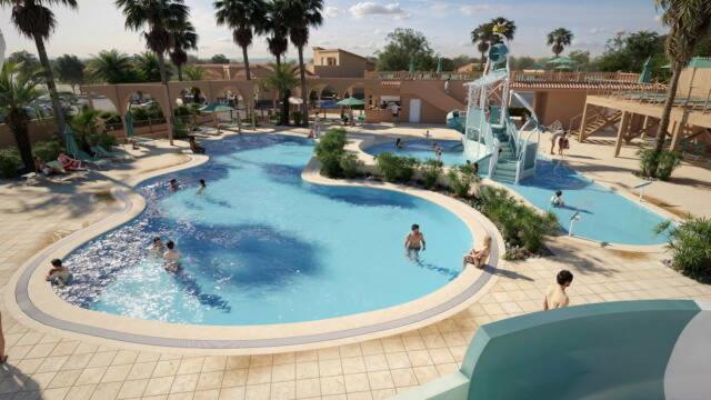 a group of people in a swimming pool at a resort at Camping le Neptune in Argelès-sur-Mer