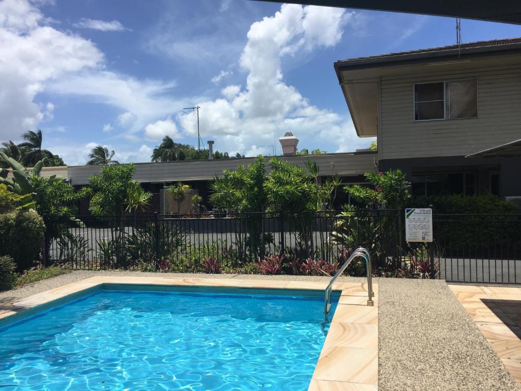 a swimming pool in front of a house at Country Plaza Motor Inn in Mackay