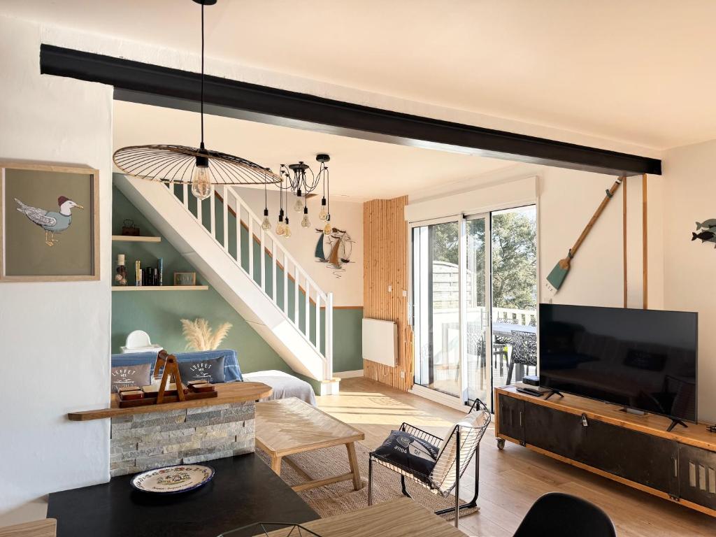 a living room with a tv and a staircase at Ti-annez mor in Bénodet