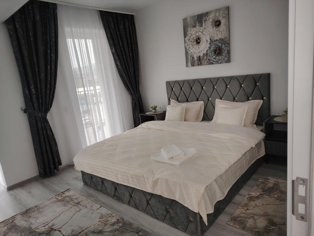 a bedroom with a large bed with a large window at Panorama Loft in Gura Humorului