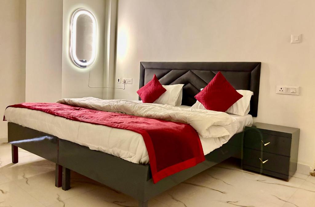 a bedroom with a large bed with red pillows at Hotel Divine in Faridabad