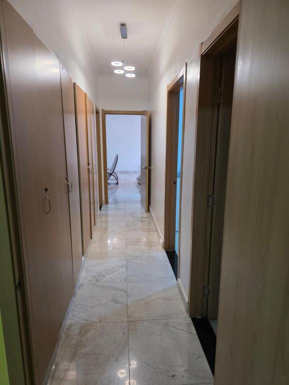 a long hallway with doors and a tile floor at N24 Confy apartment in Luanda