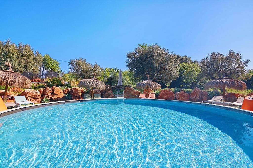 a large swimming pool with chairs and umbrellas at Casa Osga in Moncarapacho