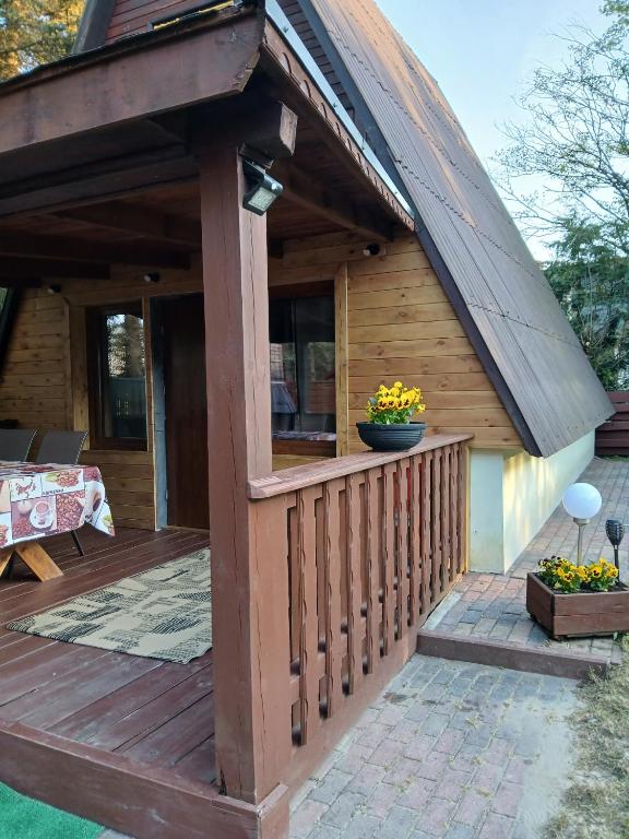 a wooden deck with a gambrel roof at Domek nad jeziorem in Jagodne