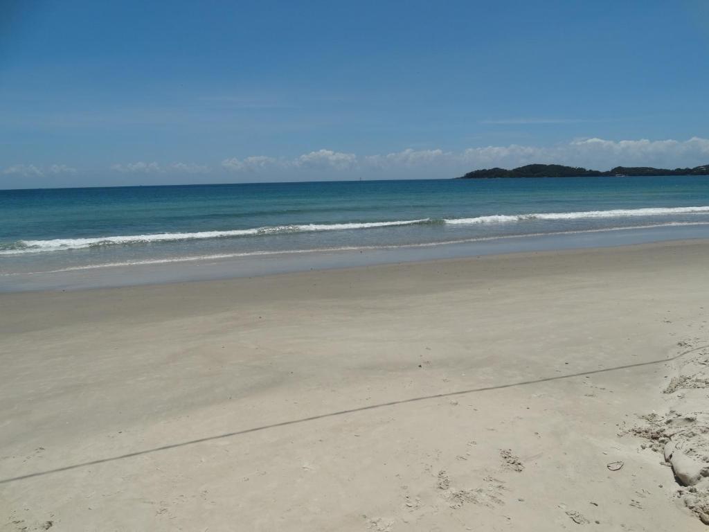 an empty beach with the ocean in the background at Apartamento Avenida in Bombinhas