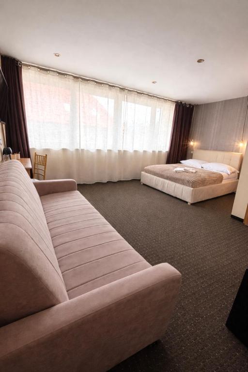 a hotel room with two beds and a couch at Willa Alexia in Kudowa-Zdrój