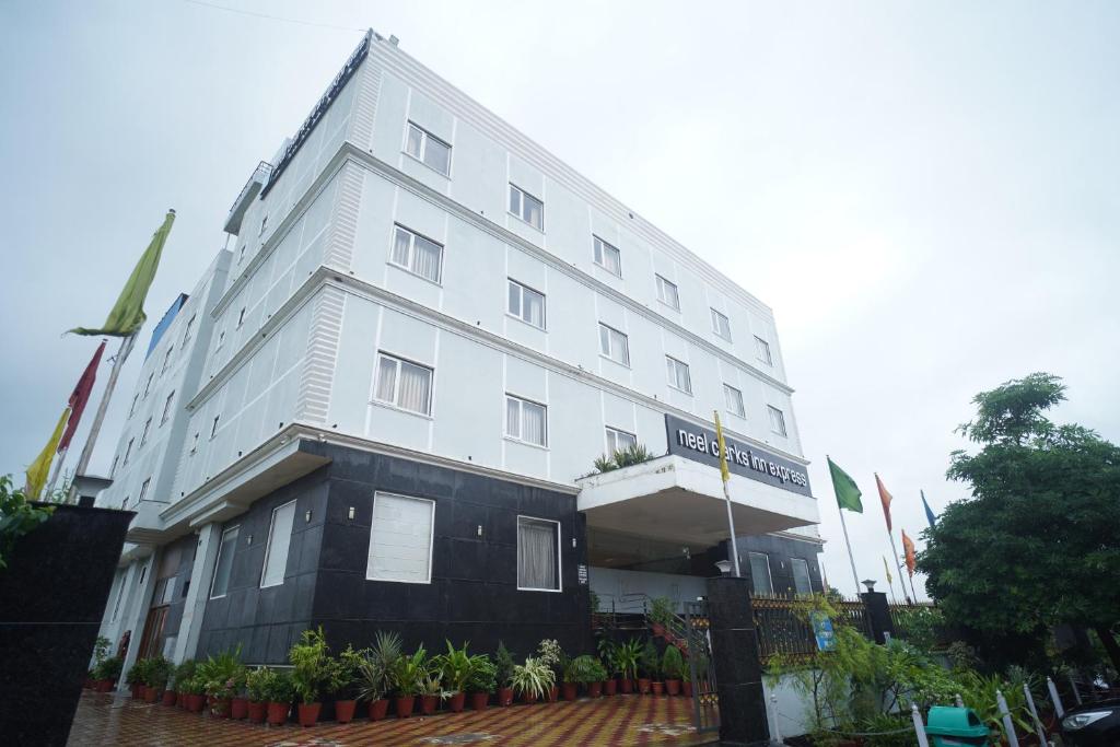 a white building with plants in front of it at Neel Clarks Inn Express in Agra
