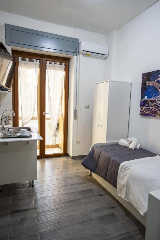 a bedroom with a bed and a kitchen with a sink at B&B dalla Nonna in Salerno