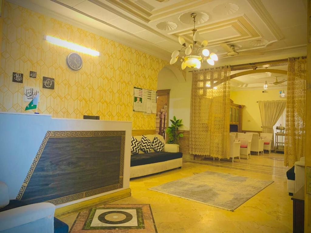 a living room with yellow walls and a couch at The Eastern Lodge in Islamabad