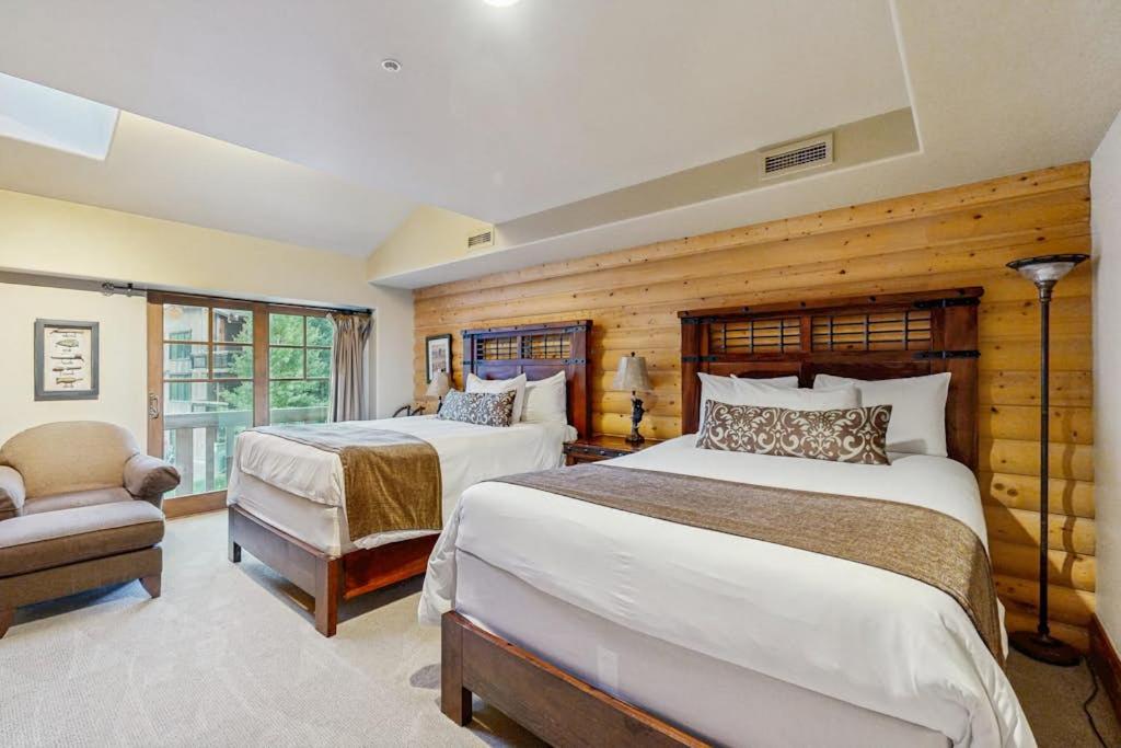 a bedroom with two beds and a chair in it at Hotel studio with views fireplace & close to everything in Park City