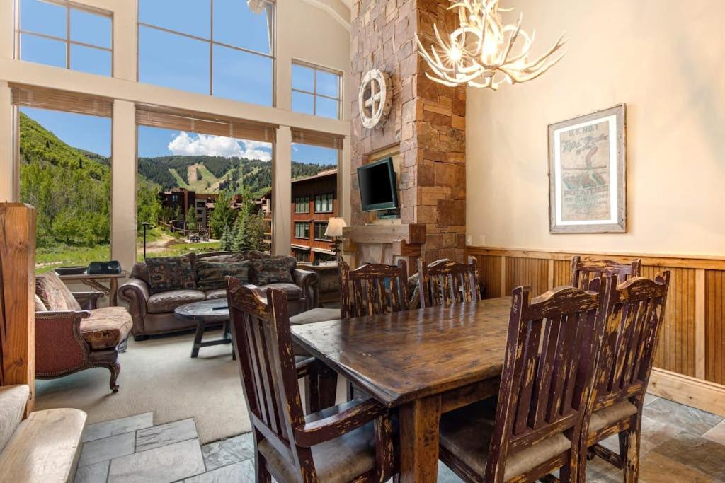 a dining room with a wooden table and chairs at Epic view condo with fireplaces & close to everything in Park City