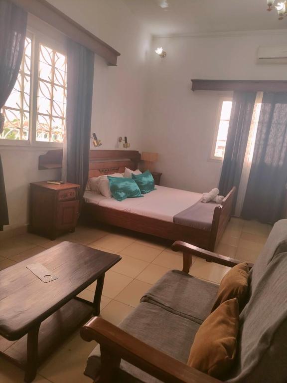 a living room with two beds and a table at RAOOF HOTEL in Mahajanga