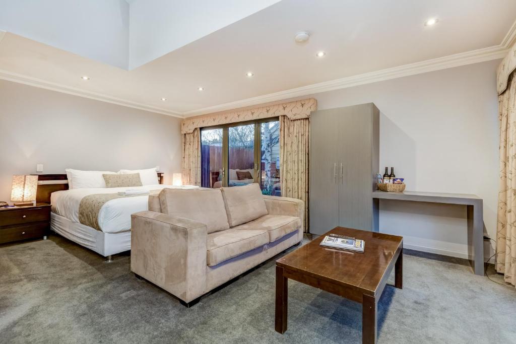 ein Schlafzimmer mit einem Bett, einem Sofa und einem Tisch in der Unterkunft Seymours On Lydiard in Ballarat