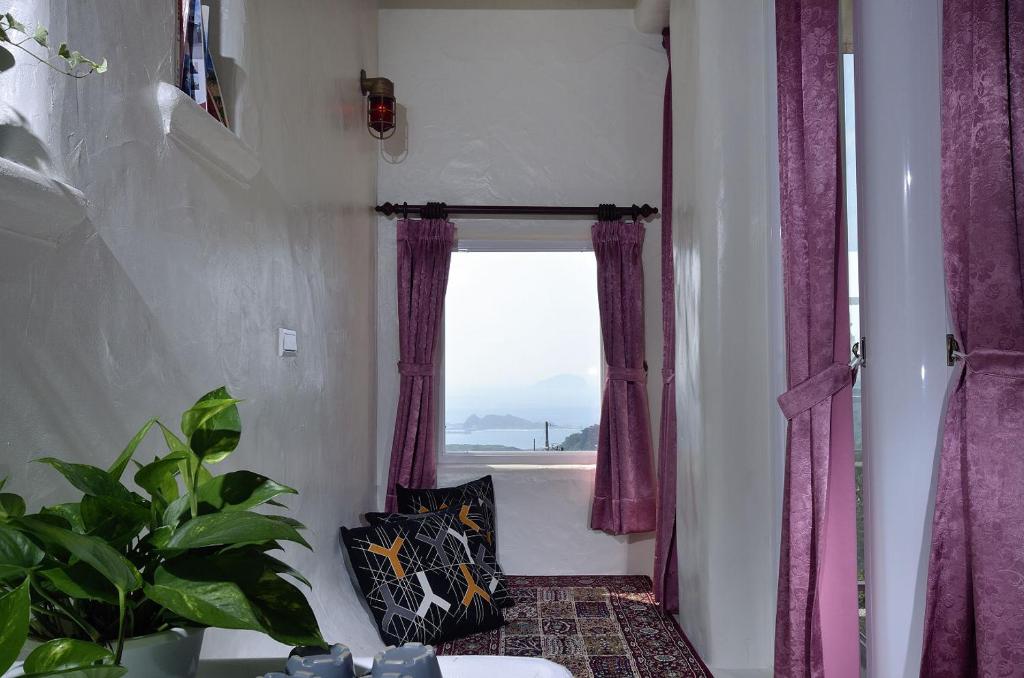 a room with a window with purple curtains at Sunny Room in Jiufen