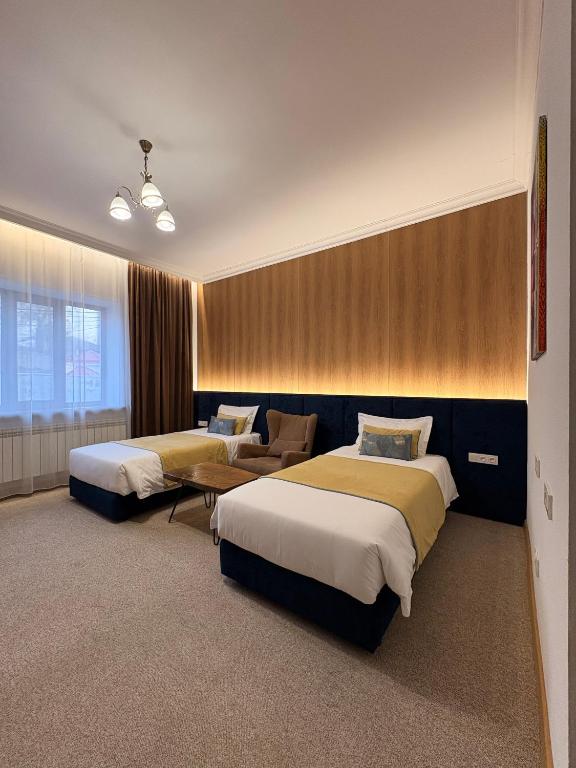 a hotel room with two beds and a couch at Keremet Hotel in Almaty