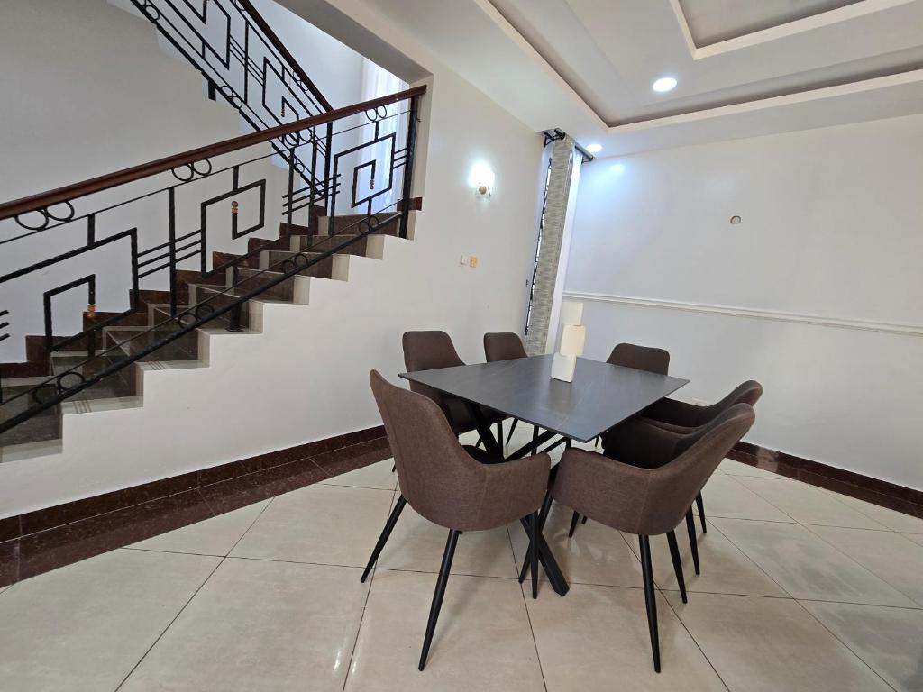 a dining room with a black table and chairs at Impala Villas in Mombasa